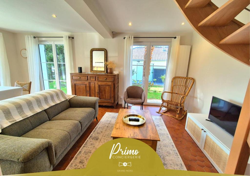 a living room with a couch and a table at Maison La Côtière proche plage avec parking in Camiers