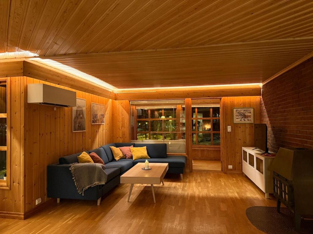 a living room with a blue couch and a table at Charming and spacious wooden house right in the city centre in Tromsø