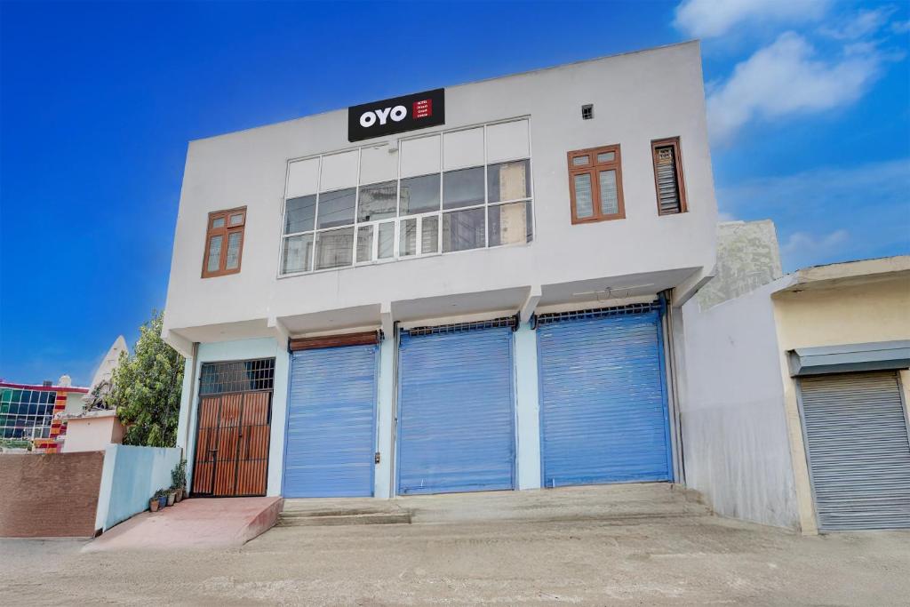 a white building with four garage doors on it at Hotel O Dream Guest House in Rudrapur