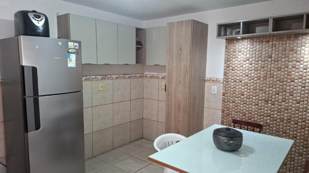 a kitchen with a refrigerator and a table in it at Casa Ribeiro in Canguçu
