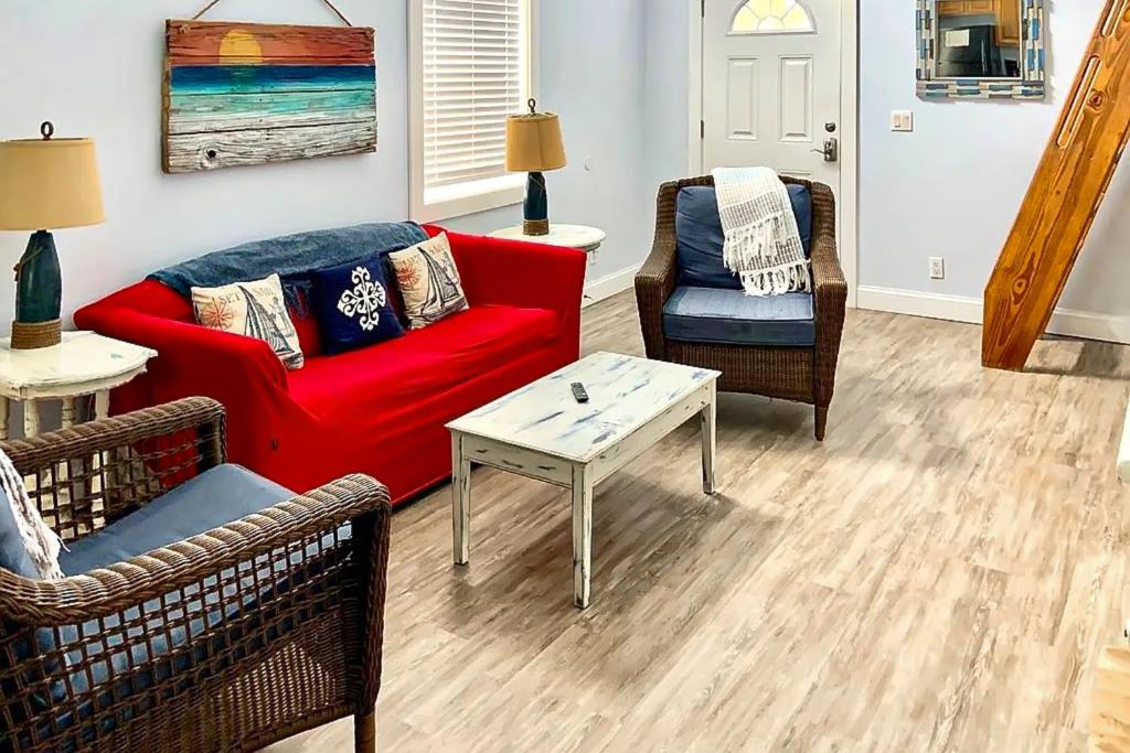 a living room with a red couch and two chairs at Neptunes Palace A1 in Saint George Island