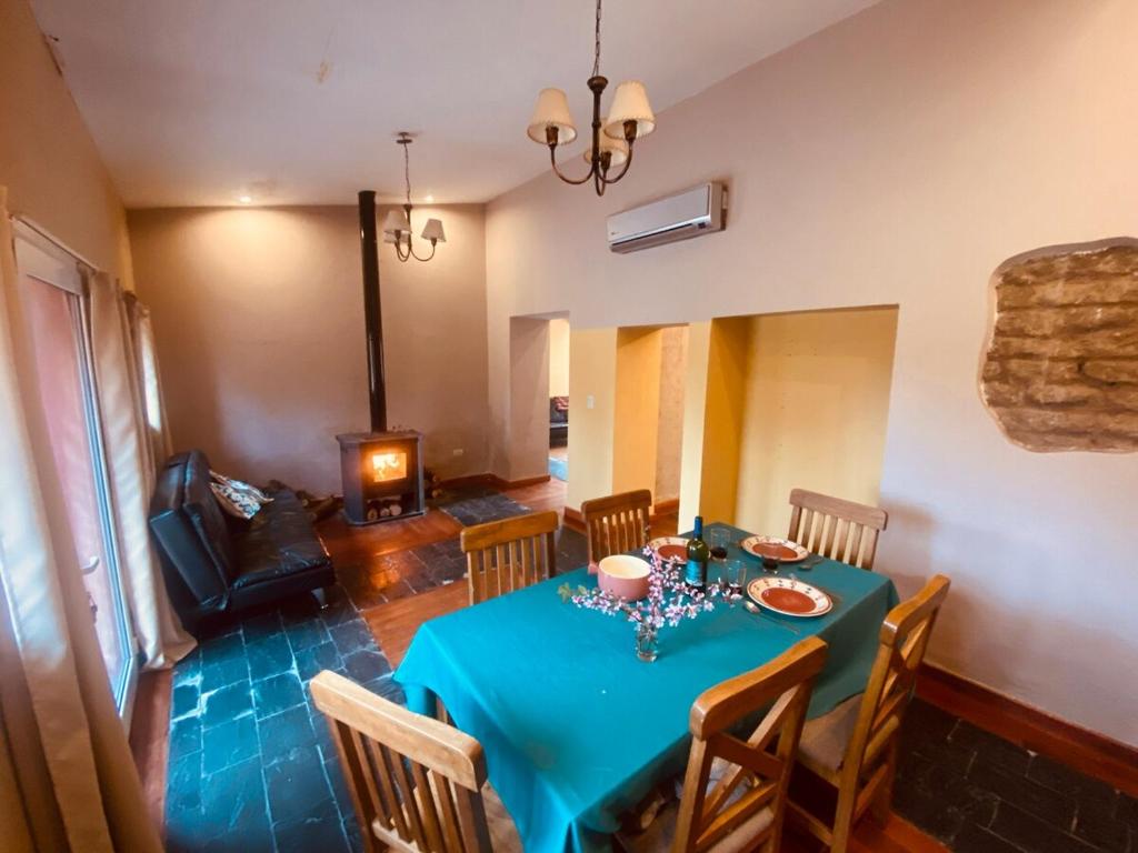 una sala da pranzo con tavolo blu e camino di Berta Vidal - Confort, Jacuzzi and Naturaleza a El Durazno