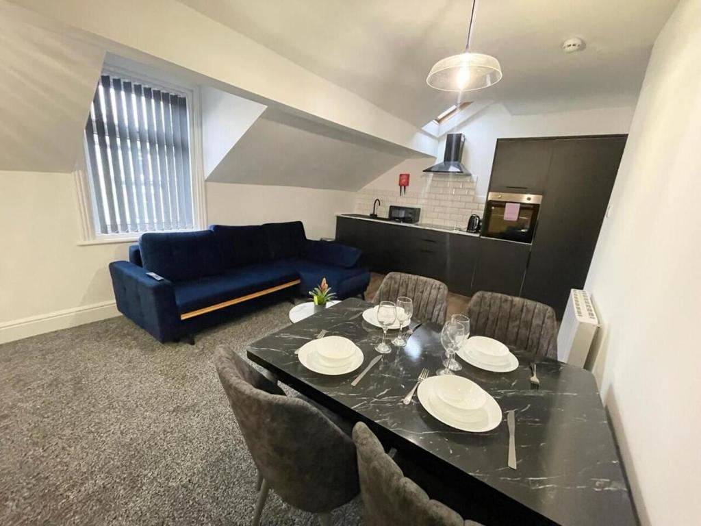 - un salon avec une table à manger et un canapé bleu dans l'établissement Stylish Flat 1BR Sofa Bed Walk to Pier & Tower, à Blackpool