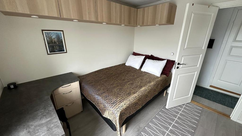 a small bedroom with a bed and a door at Penthouse in Kristiansand