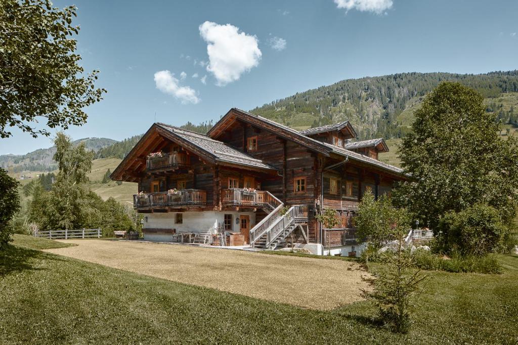 una grande casa di legno in mezzo a un campo di Apartment Tilliach a Untertilliach