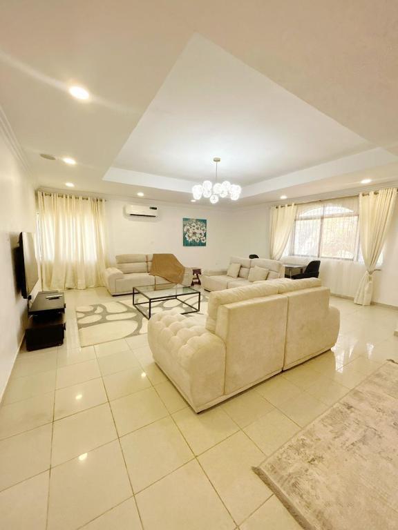 a large living room with couches and a tv at Tulip in Abuja