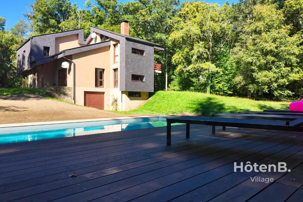 una terraza de madera con piscina y una casa en Villa Les Chabannes Pool Billiards & Leisure, en Feytiat