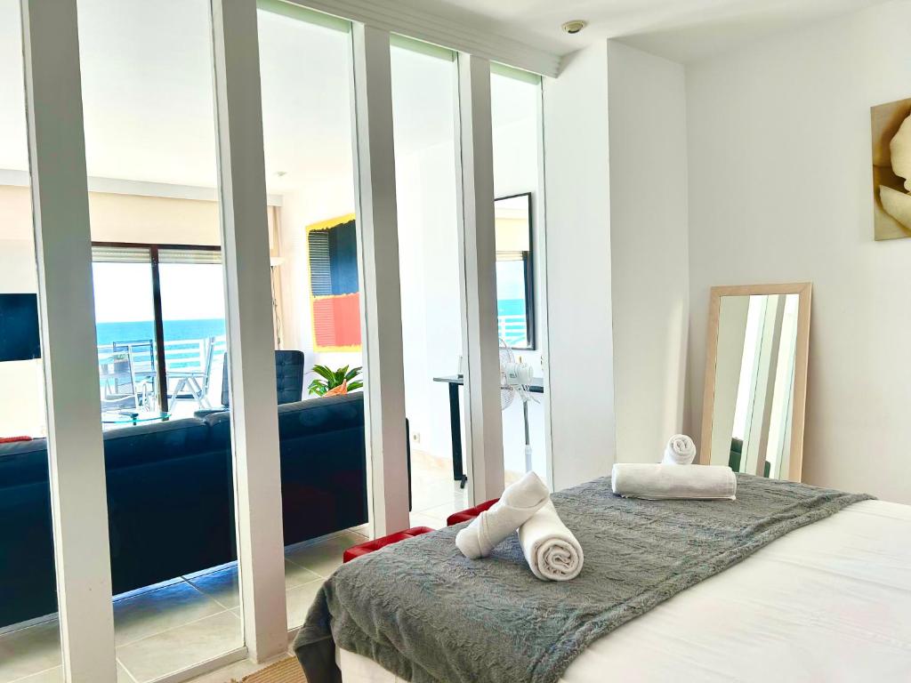 a bedroom with a bed with a view of the ocean at Sunrise Atic Altea Beach by DelucaCo in Altea