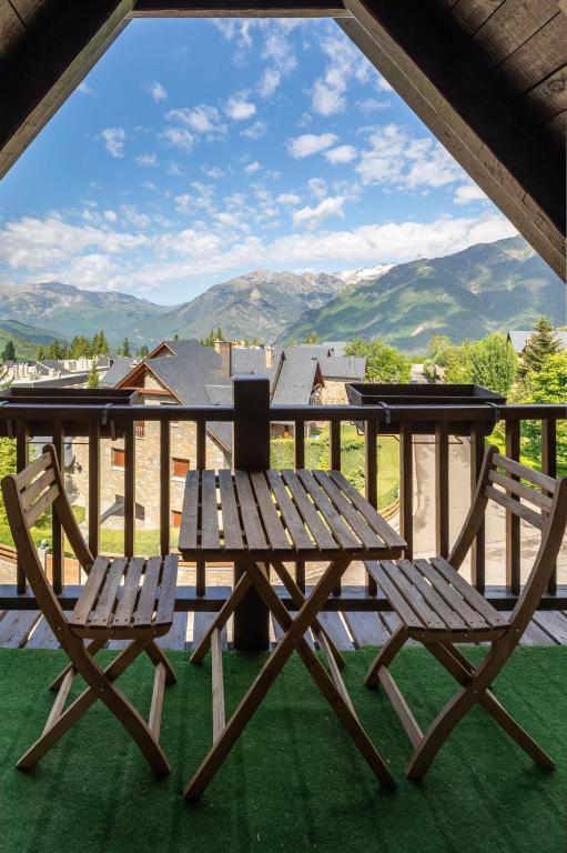 a picnic table and two chairs on a porch with a view at Las casitas de mache - 5F in Cerler
