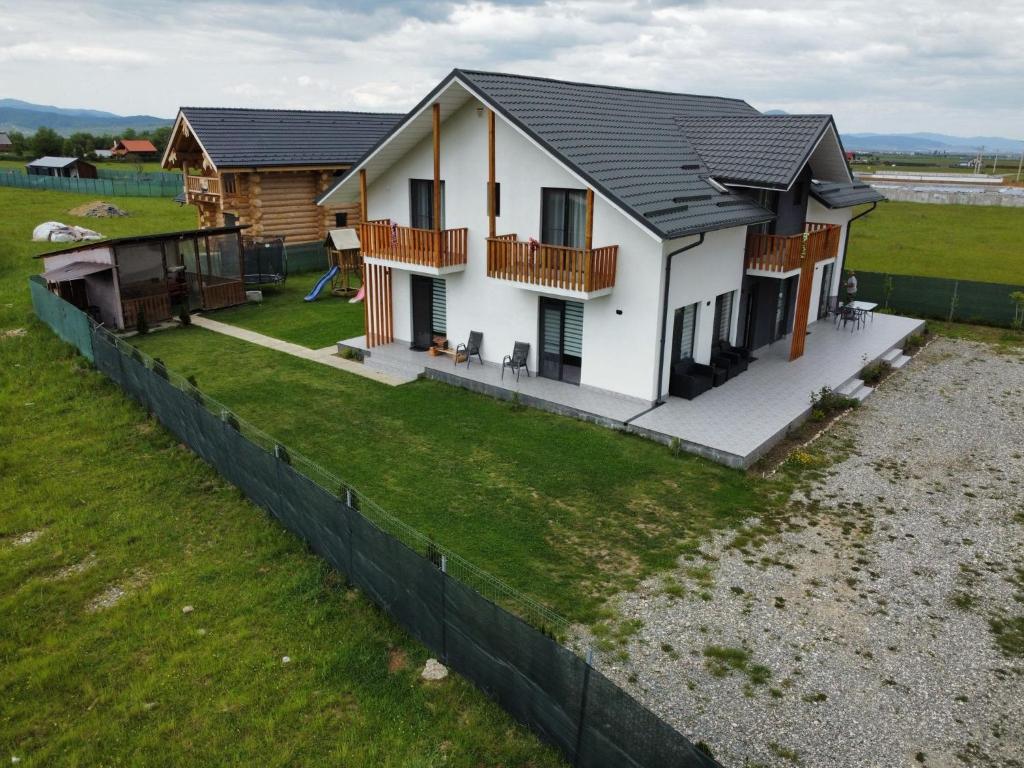 a house with a fence in front of it at CASA VIKI in Bănicel