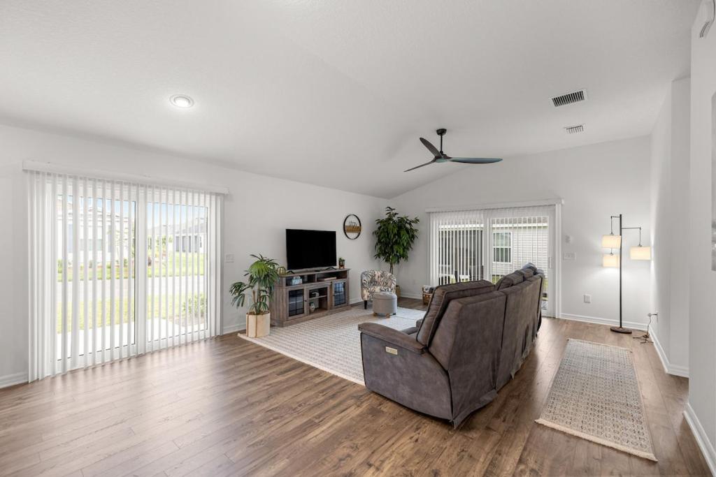 a living room with a couch and a tv at Spacious 2BR in The Villages With Golf Cart and King Bed in Sumterville