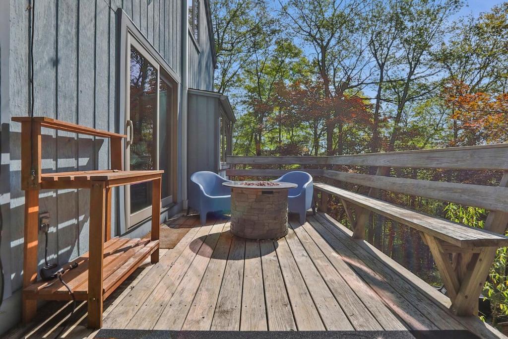 a wooden deck with a bench and a table at House Under The Cliff in New Paltz