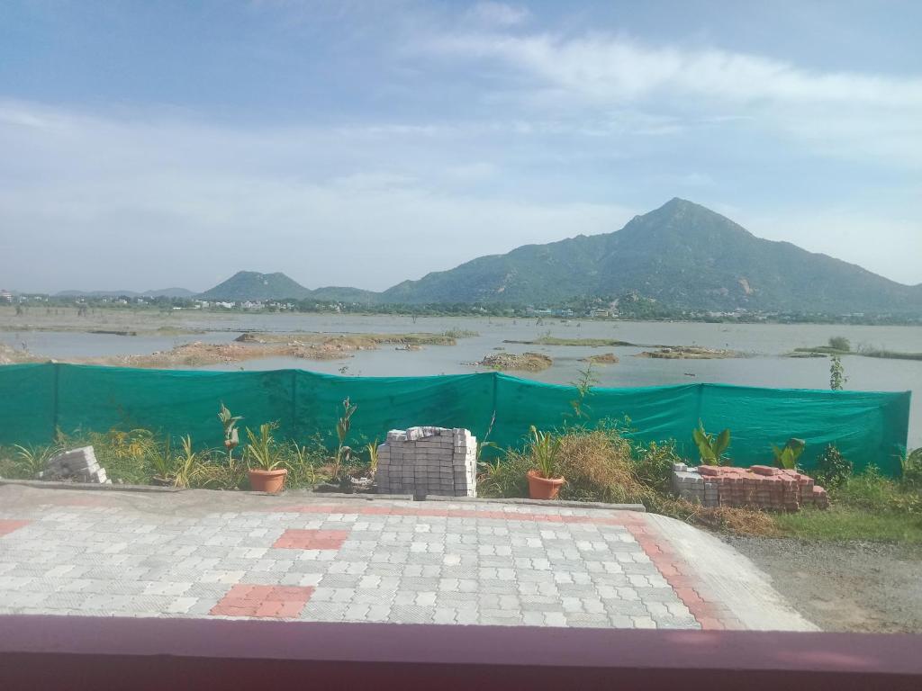 Blick auf einen Fluss mit Bergen im Hintergrund in der Unterkunft Sai Arunachala Farmstay in Tiruvannāmalai