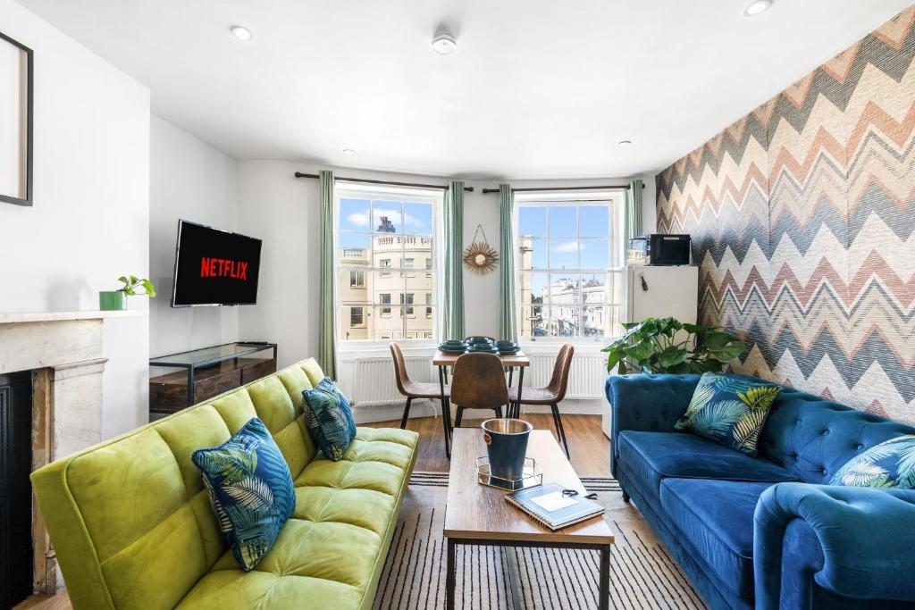 Una sala de estar con dos sofás azules y una mesa. en Brighton 2 Bed Brunswick, en Brighton & Hove