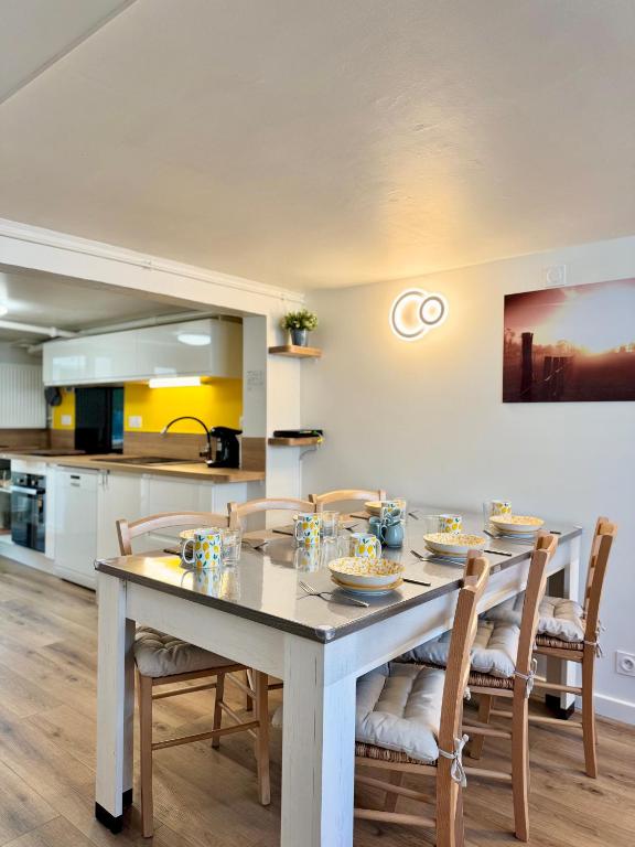 a kitchen and dining room with a table and chairs at La Maison d'Eugène, Rennes centre in Rennes