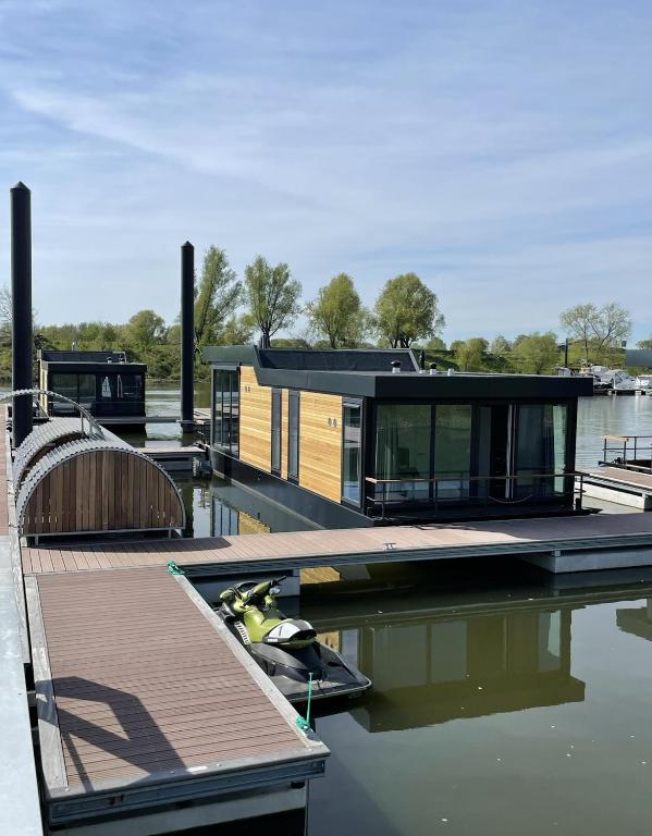 a house is sitting on a dock in the water at De Maasterp - Watervillage 2 in Ohé en Laak