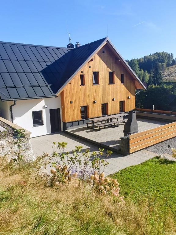 a large wooden barn with a bench in front of it at Chalet Lucie in Bedřichov