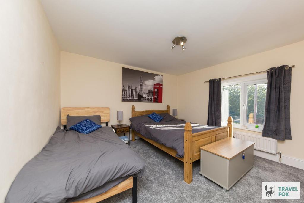 a bedroom with two beds and a window at Rocester Rest close to Alton Towers & JCB, Netflix in Rocester