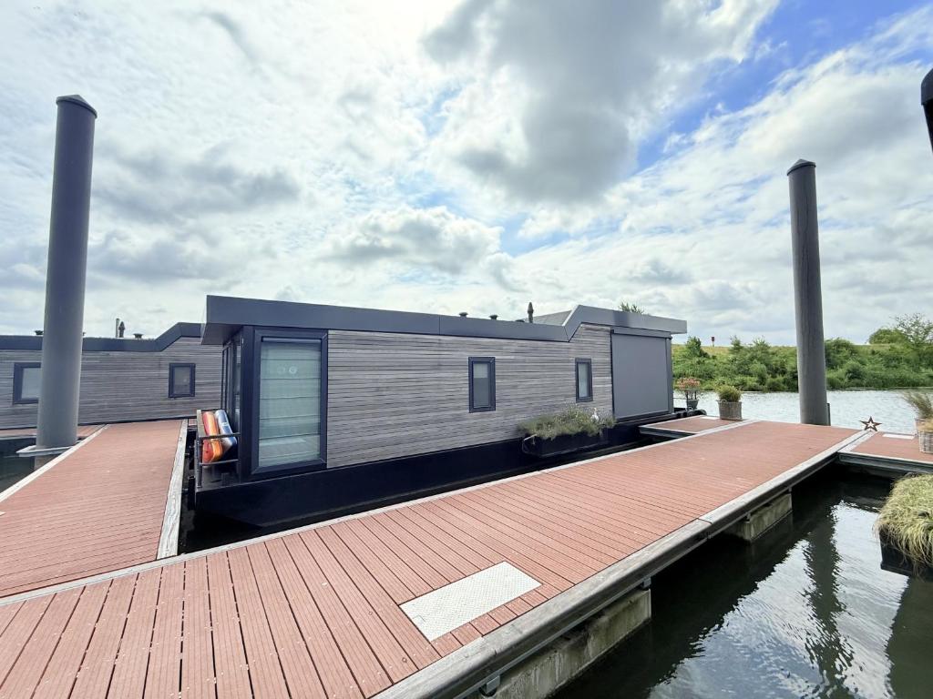 a house on the water with a dock at De Maasterp - Watervillage 21 in Ohé en Laak