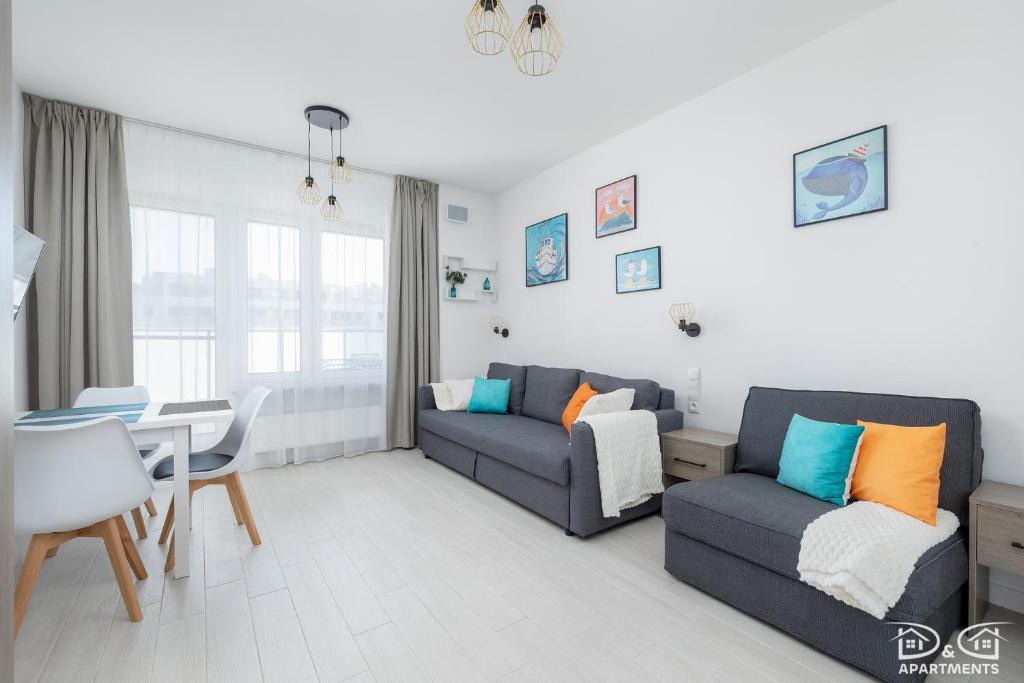 a living room with two couches and a table at Mewa Aquamarina Onyx D&D Apartments in Międzyzdroje