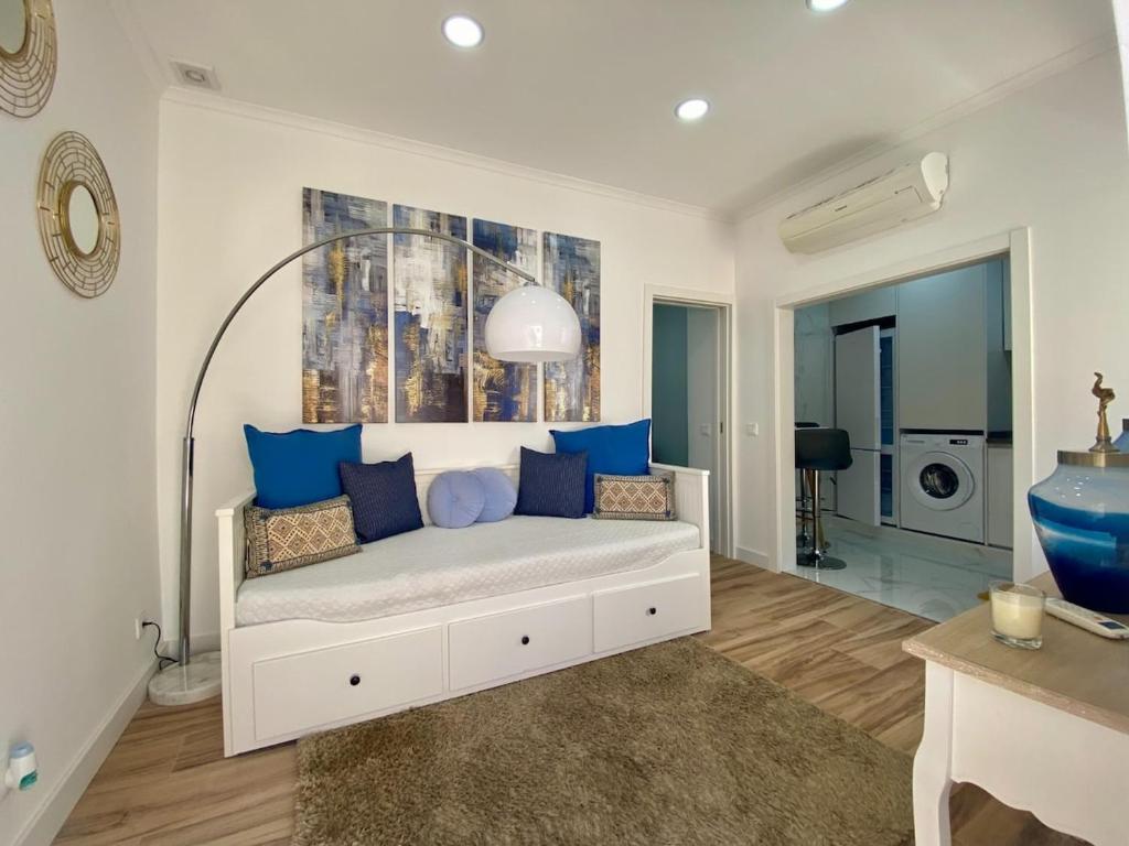 a bedroom with a bed with blue pillows at Light Keys-Setubal DownTown&Beach in Setúbal