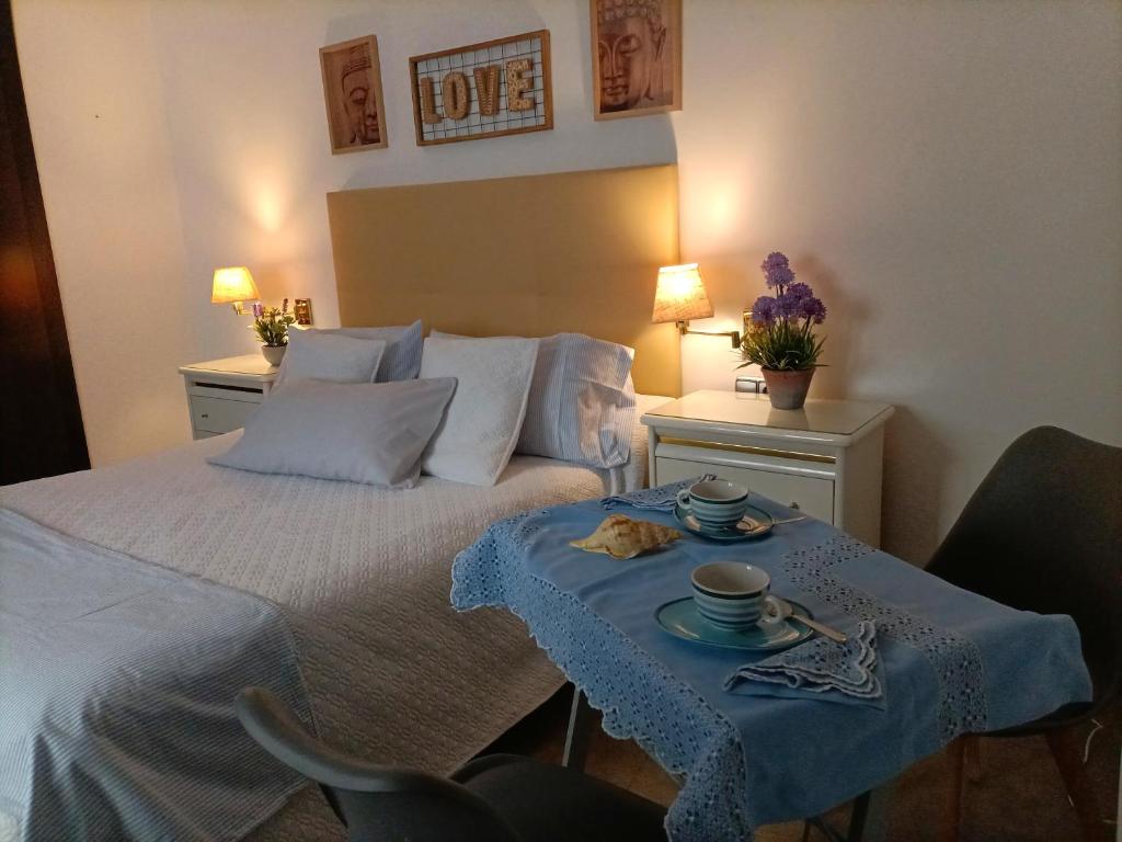 a bedroom with a bed with a table with two cups on it at Apartamento Centro Espinel in Ronda