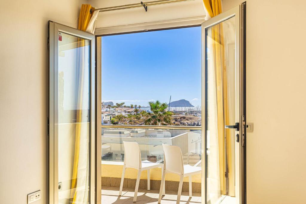 サンミゲル・デ・アボナにあるSun Bay Ocean Retreat Villaのガラスドアからバルコニー(テーブル、椅子付)へアクセスできます。