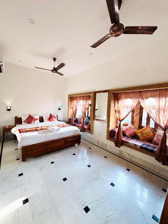 a bedroom with a large bed and two windows at Hotel Muskan Heritage in Jaisalmer