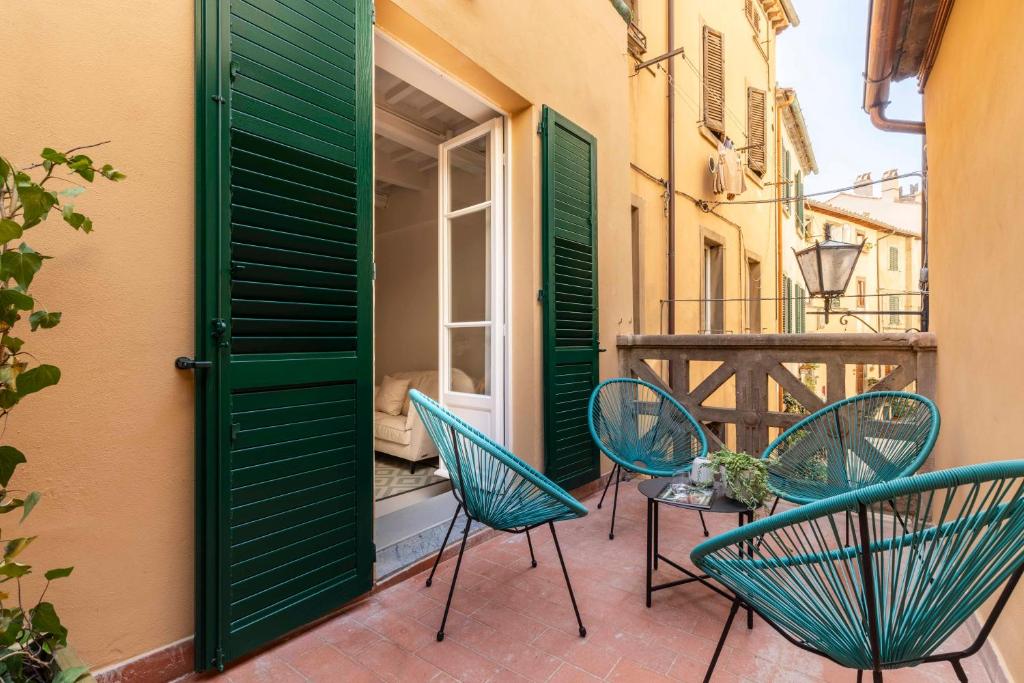 eine Terrasse mit Stühlen und einem Tisch auf einem Balkon in der Unterkunft Ruga23 -1 in Cortona