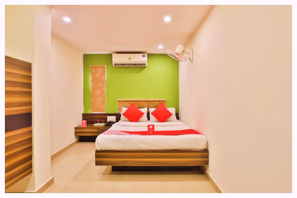 Un dormitorio con una cama con una pared verde. en Hotel S-R Palace Near City Bus Stand - Fully Air Conditioning Hotel - Luxury & Spacious Room -Best Hotel In Bhubneshwar, en Cuttack