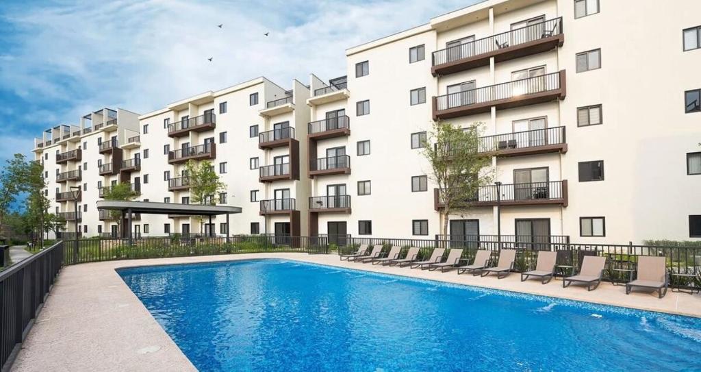 a swimming pool in front of a building at Luxury apartment 2 minutes from BBVA Stadium in Monterrey
