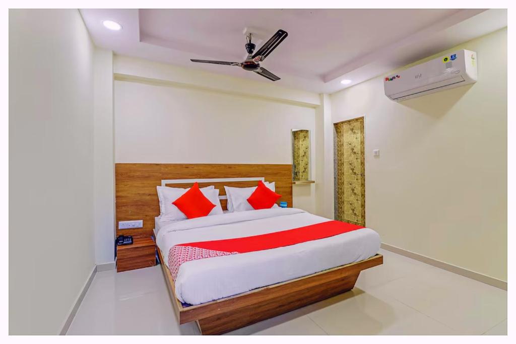 a bedroom with a bed with red pillows at Hotel Nandan- Residency Near Bus Stand-Nandankanan Zoo- Fully Air Conditioning Hotel - Luxury & Spacious Room -A Premium Hotel in Cuttack