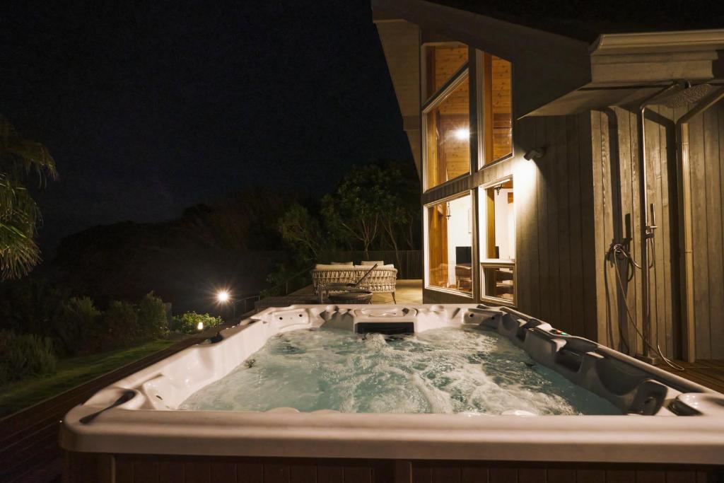 a jacuzzi tub in front of a house at night at Monterey House by SANA in Tateyama