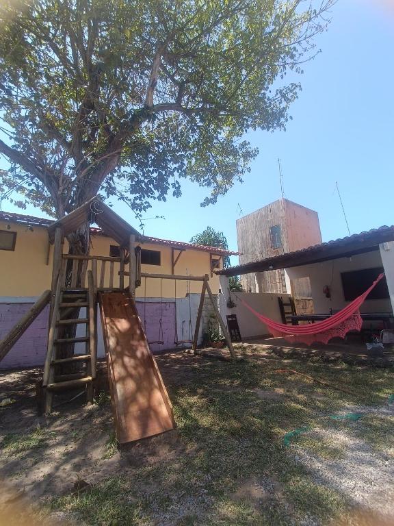 a playground with a tree and a slide at Sol guest house in Pipa