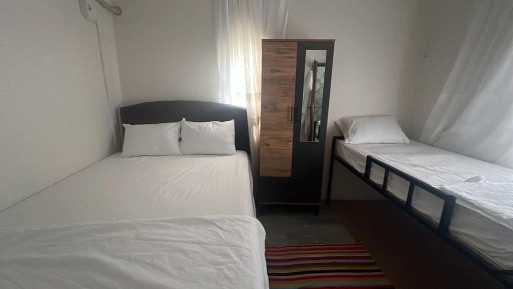 two twin beds in a room with a door at Zaloğlu Oda in Midyat
