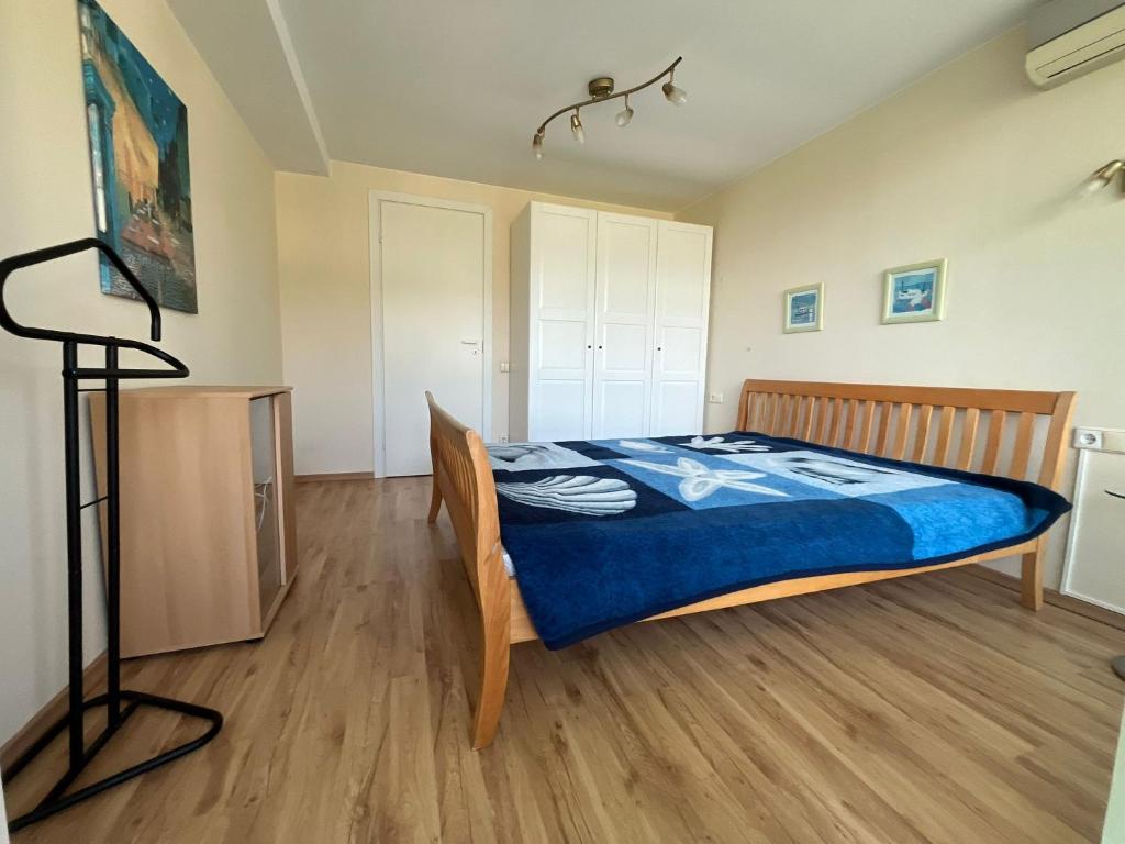 a bedroom with a bed with a blue blanket at Atgaiva in Palanga