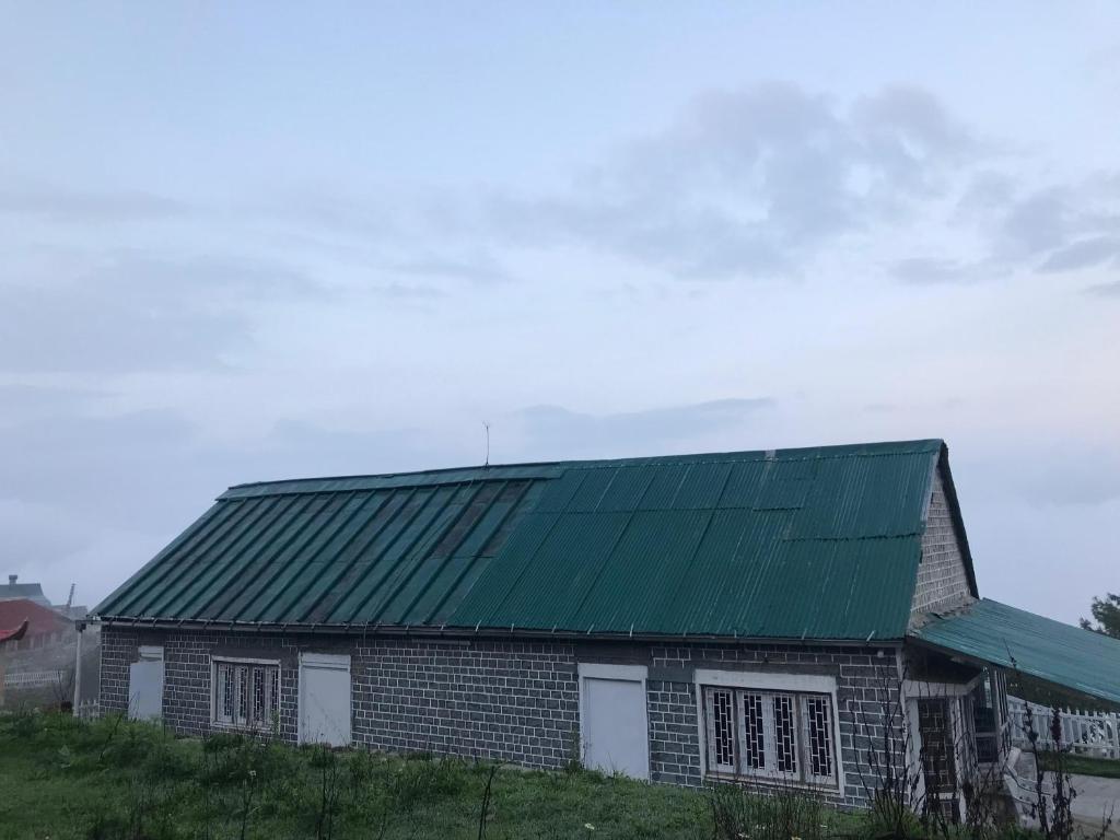 an old brick house with a green roof at White Bird Villa in Khaira Gali