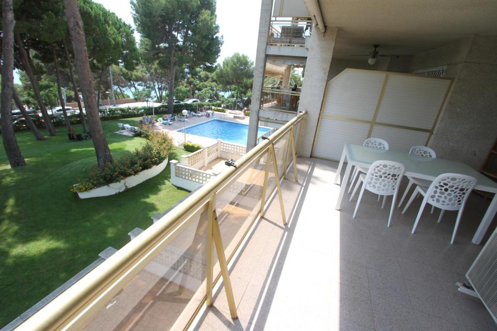薩洛的住宿－For a Stay Cala Dorada，一个带桌椅的阳台和一个游泳池