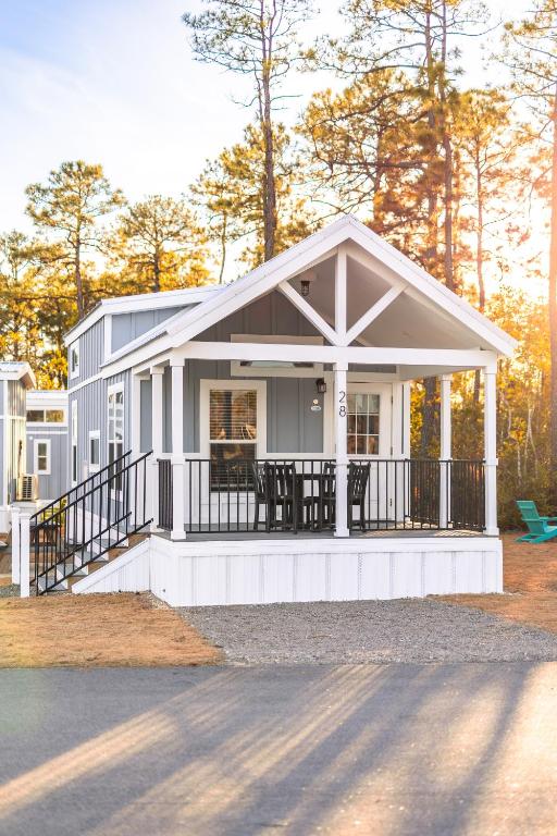 a small white house with a porch at Oceans RV Resort in Holly Ridge