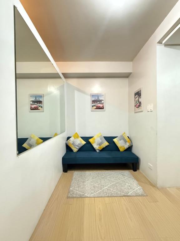 a room with a blue couch and a mirror at MPlace Tower D Condo Unit in Manila