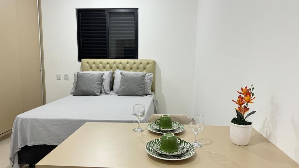 a room with a bed and a table with two glasses at 303-4 · Studio Próximo UniEvangelica in Anápolis