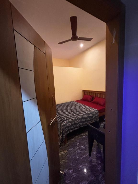 una camera da letto con un letto e un ventilatore a soffitto di Surabhi homestay a Gokarna