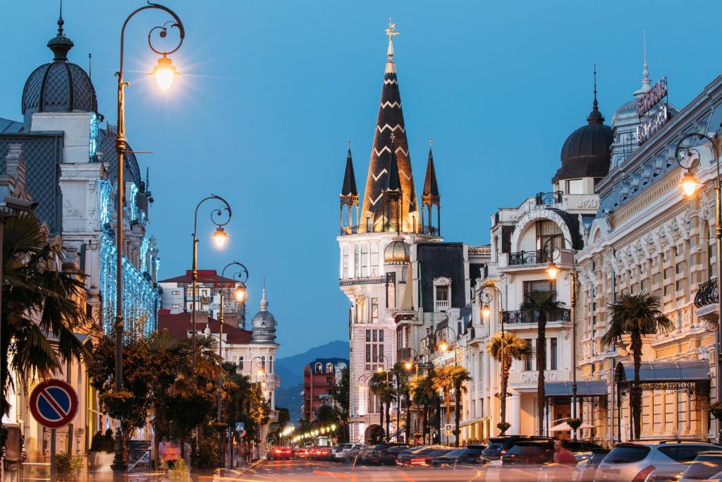 een stadsstraat met gebouwen en een klokkentoren bij Hotel Indigo Batumi - Old Town by IHG in Batoemi