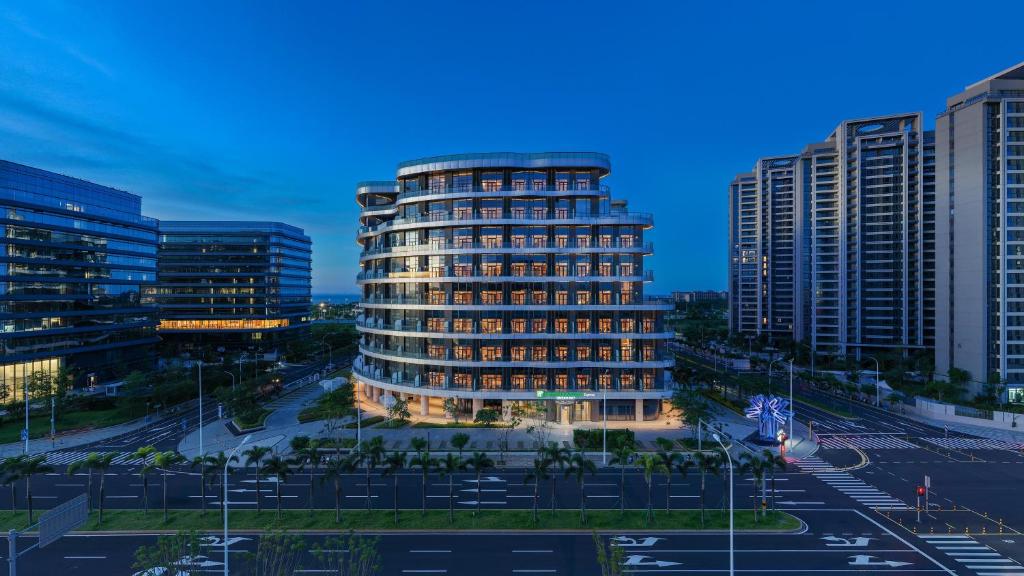 a tall building in the middle of a city at Holiday Inn Express Haikou Int'l Duty Free City by IHG in Haikou