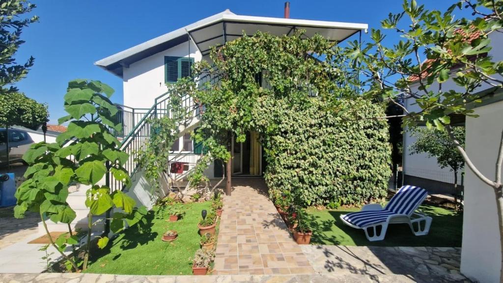 a house with a blue and white chair in the yard at Holiday house with a parking space Jadrija, Sibenik - 24931 in Jadrija