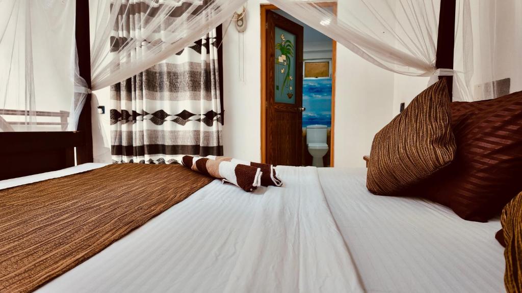 Un dormitorio con una gran cama blanca con una cortina. en DNA secret palace, en Tangalle