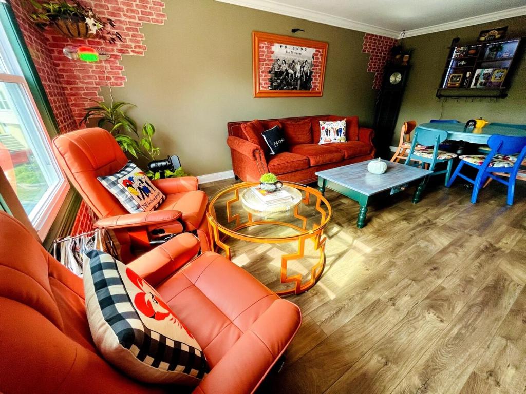a living room with orange furniture and a table at Schaumburg Paradise Oasis with a secret garden and private Pool in Schaumburg