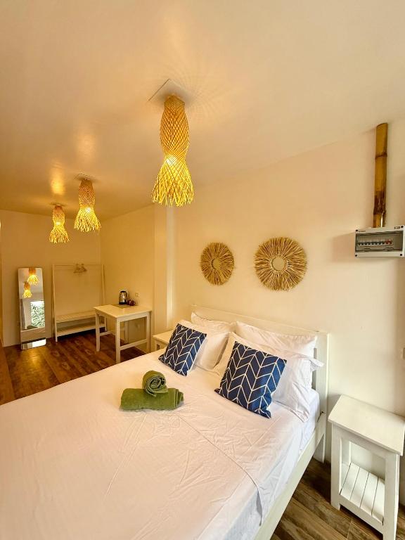 a bedroom with a large white bed with blue pillows at Utopia Port Barton in San Vicente