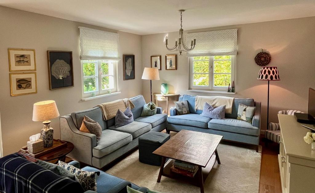 a living room with blue couches and a table at Beautiful Villa & Garden in Munich in Munich