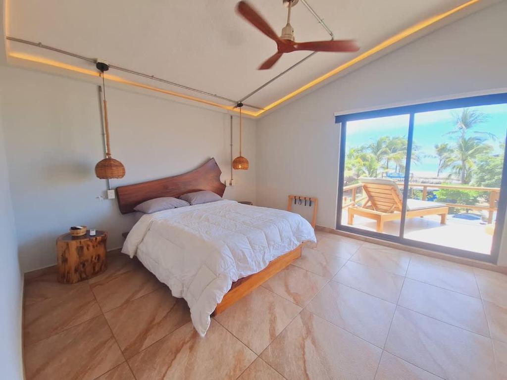 a bedroom with a bed and a large window at Espectacular Suite Frente a Playa Zicatela 1BDR in Brisas de Zicatela